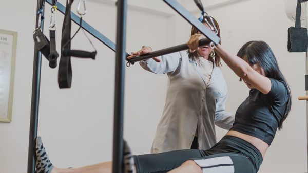 Exercício no Pilates Cadillac, acompanhado pela fisioterapeuta