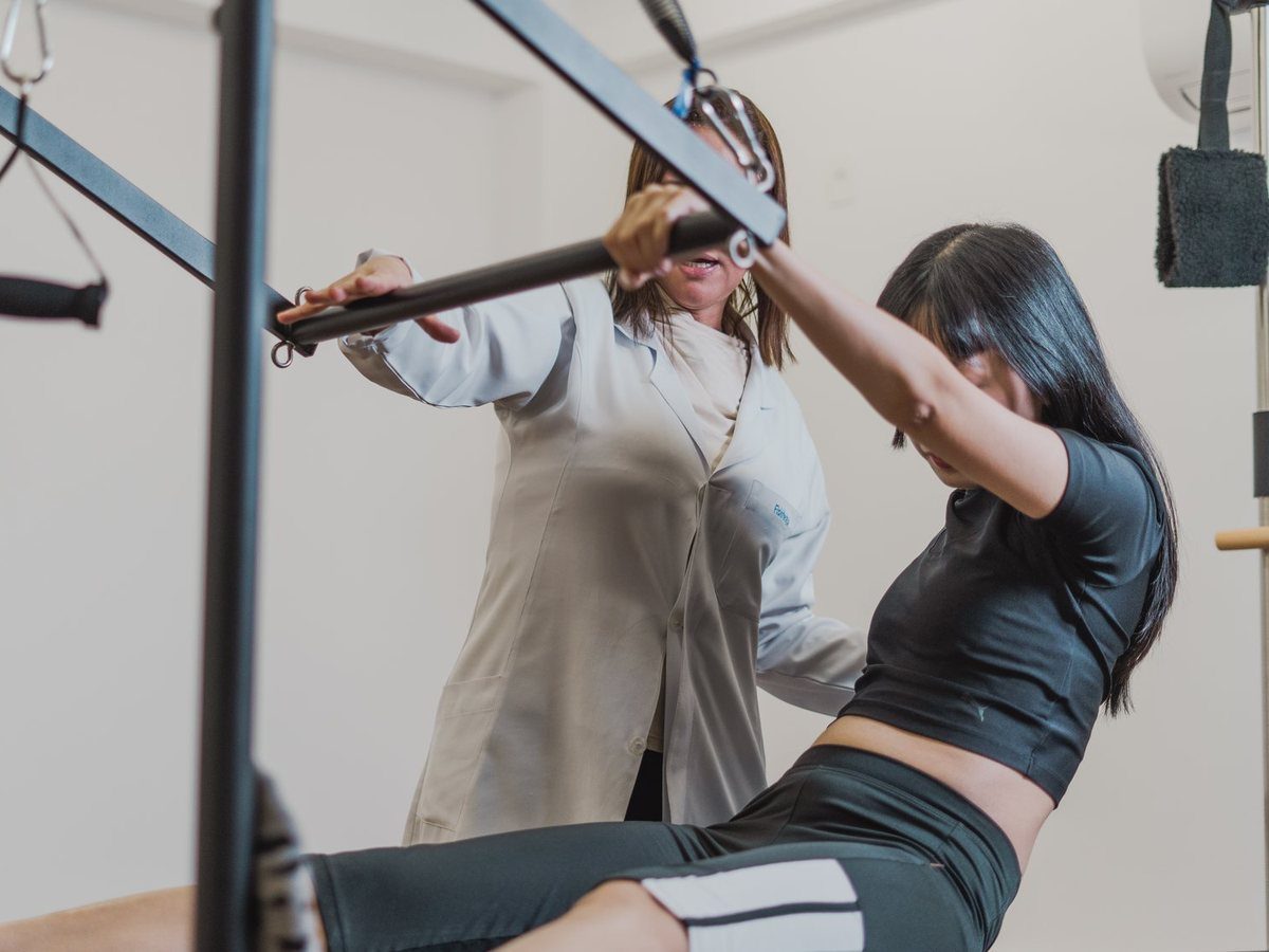 Exercício no Pilates Cadillac, acompanhado pela fisioterapeuta